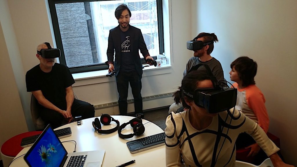 A group testing early virtual-reality headsets around a studio table.